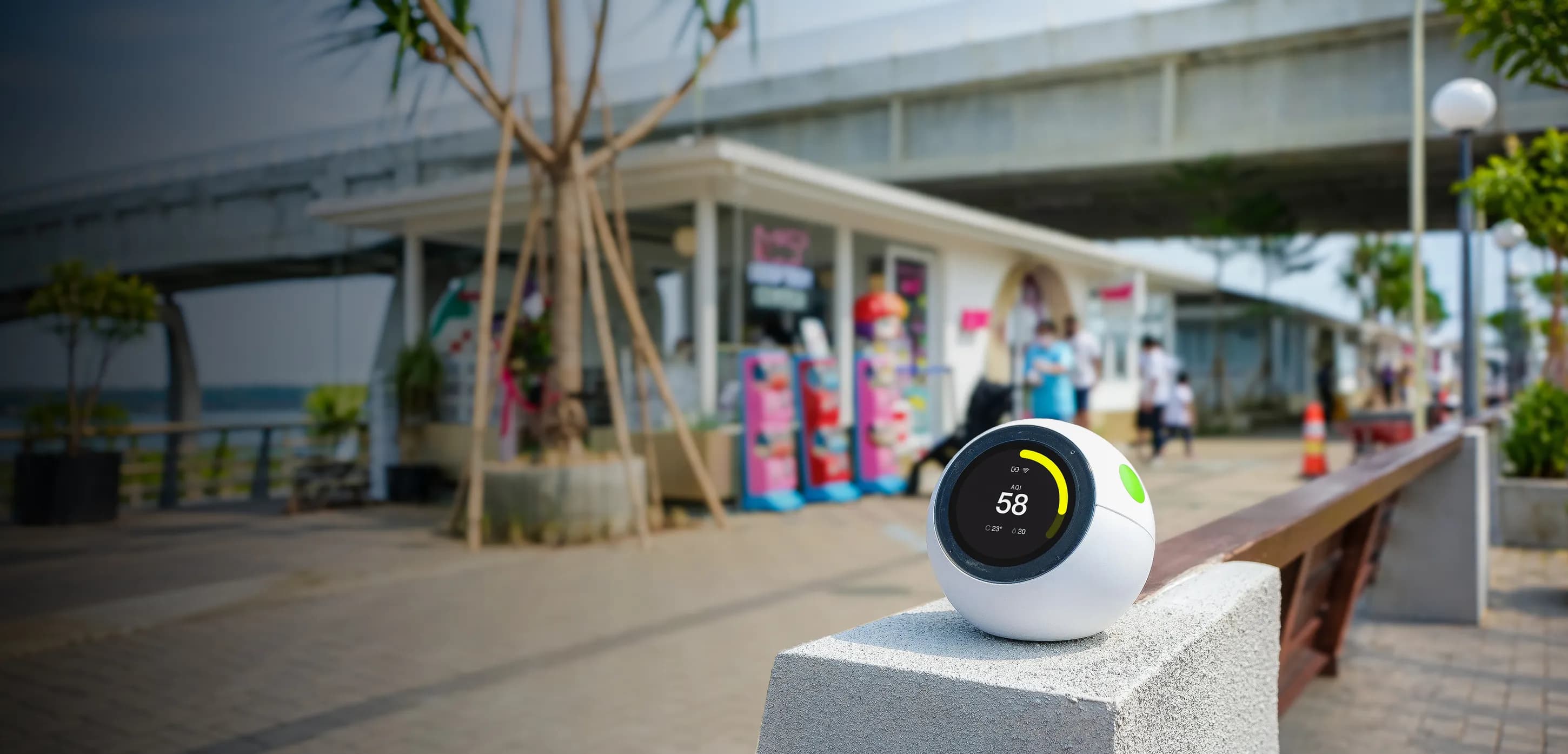 ecoCare Air Sensor di atas pembatas beton di area luar ruangan yang ramai