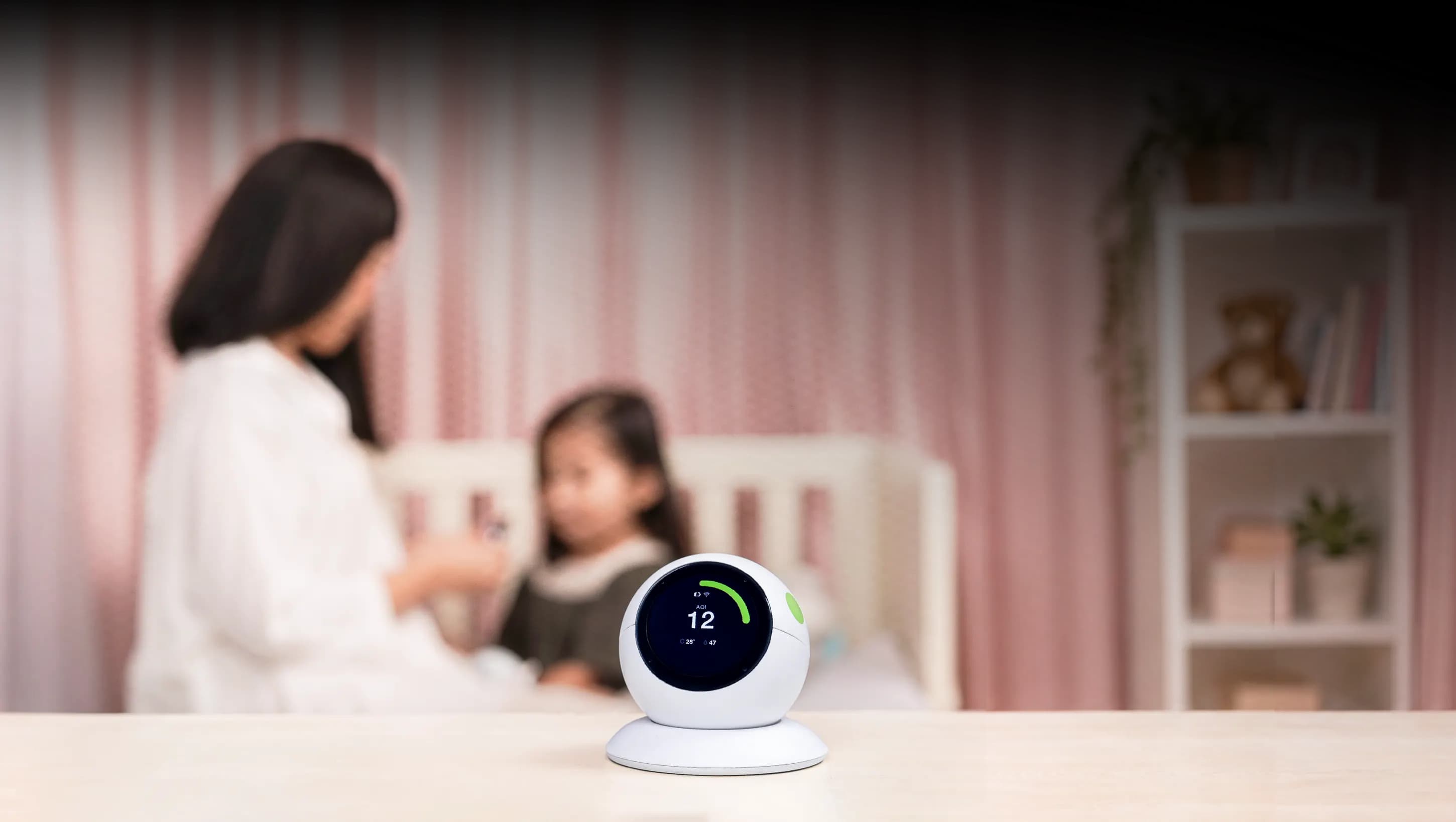 Ibu dan anak bermain di kamar dengan ecoCare Air Sensor di atas meja