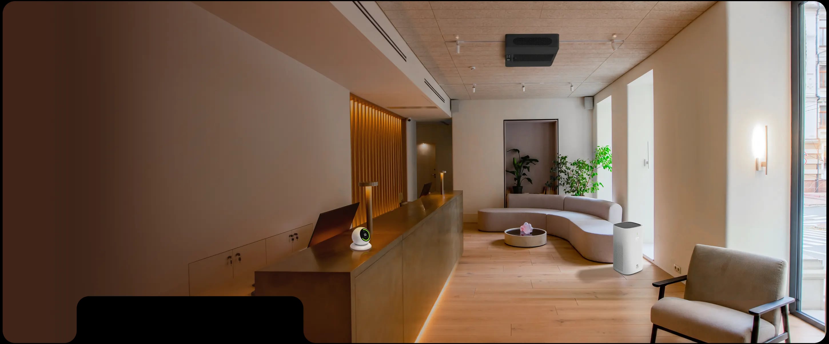 Lobi kantor modern dengan meja resepsionis, sofa, dan sensor ecoCare Pure Air